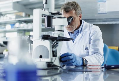 scientist-looking-through-microscope-487041749-58d5504a5f9b584683dc6de6